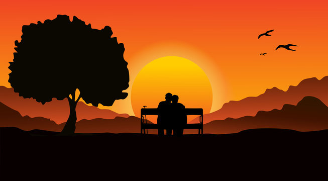 An elderly couple sitting on a bench in a mountainous area, next to a large tree. Look at the beautiful sunset.