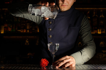 Bartender pouring alcoholic drink into the glass