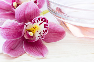 Fototapeta na wymiar Spa and wellness setting with orchid on wooden white background closeup