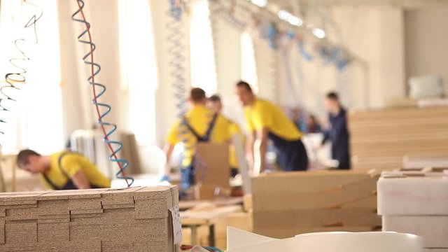 Furniture factory workers in yellow overalls collect furniture, Furniture manufacture,, industrial interior,small depth of field