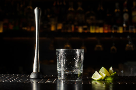  itrus press, cocktail glass and slices of lime on the bar counter