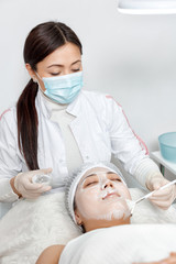Naklejka premium cosmetologist puts a mask on the face