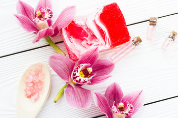 Spa and wellness setting with orchid and rose sea salt in a can on wooden white background