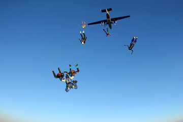 Skydivers are jumping out of a plane.