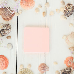 pink sheet to record and seashells on a wooden background.Travel background