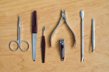 Classic metal kit of nail scissors and manicure tools on wooden background