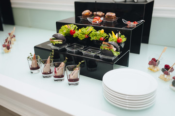 Catering buffet table with a delicious snacks. Sandwiches. Meat. Vegetables. Berries.