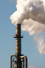 Factory emitting plumes of smoke polluting air