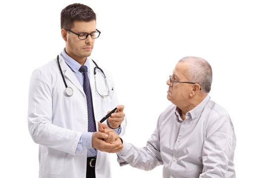 Doctor measuring the blood sugar level of an elderly patient with a glucometer