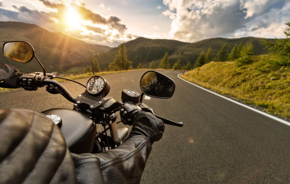 Fototapeta POV of motorbiker holding steering bar, riding in Alps