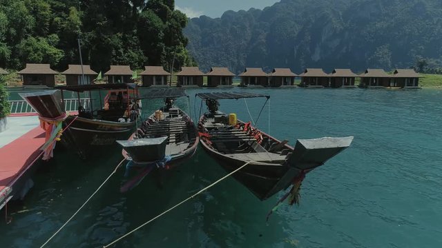 Tropical Thai jungle lake Cheo lan drone flight, wild mountains nature national park ship yacht, fishing boats
