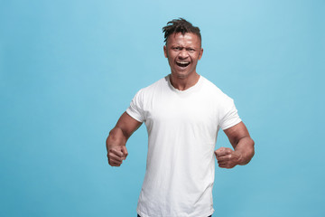 Naklejka premium The young emotional angry afro man screaming on blue studio background