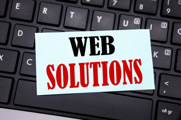 Word, writing Web Solutions. Business concept for Internet Design Plan written on sticky note paper on the black keyboard background.