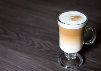 A hot and creamy Macchiato Coffee in a tall glass on a clean background
