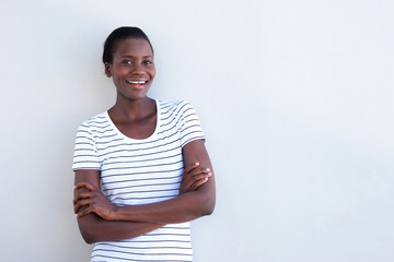 african american woman smiling with arms crossed on white background