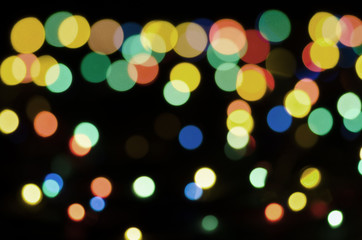 Colored blurry lights on a black background. Bokeh, soft focus