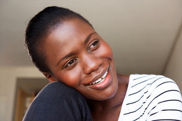 Close up happy african woman sitting at home and smiling