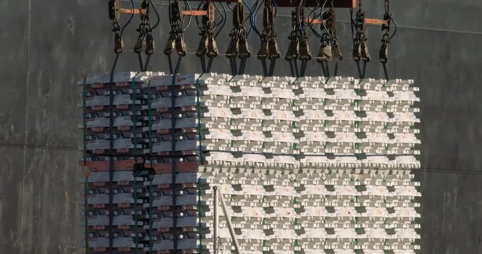 Telephoto shot of aluminum ingots being loaded onto a ship for export from Australia - 4K 30P. 