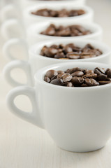 Coffee. Coffee cups and coffee beans on red wooden background.