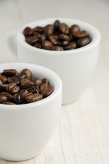 Coffee. Coffee cups and coffee beans on red wooden background.
