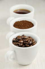 Coffee. Coffee cups and coffee beans on red wooden background.