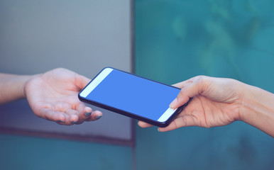 woman hand holding smartphone with blank screen to her friend