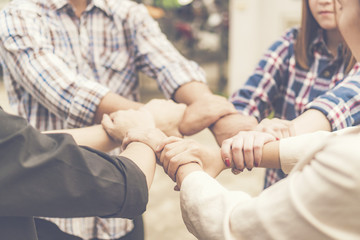 Group of business people crossed arms in pile for win. Stack of hands. Cooperation concept