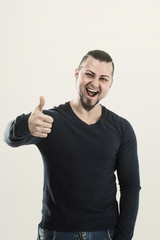 Naklejka premium athletic guy bodybuilder in jeans and t-shirt showing gesture