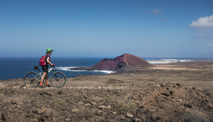 Seniorin unterwegs mit dem Mountainbike auf der Insel Lanzarote, Kanarische Inseln