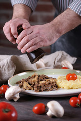 The man peppers the food