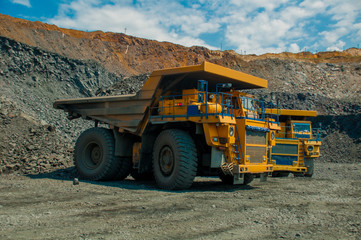 Two quarry dump trucks transport ore in the iron ore quarry