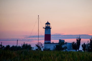 Silhouette of a lighthouse against the background of the evening sky.