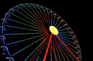 The Ferris wheel glows against the background of the night sky.
