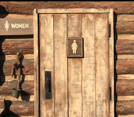 Woman rest room sign on old wooden door