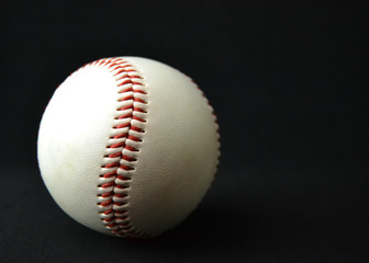 Lightly used baseball on black background