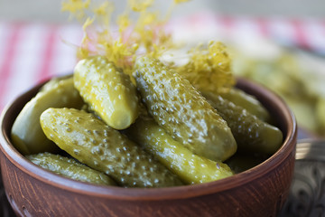 Pickled cucumbers on brown bowl. Pickles, traditional Russian snack.
