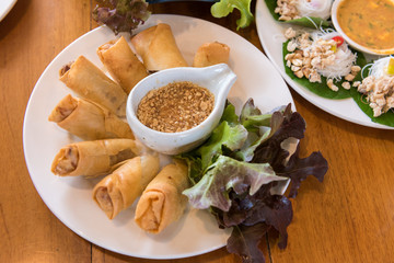 Deep fried spring rolls with vegetable in white dish on table