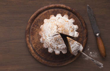 Top view on fruitcake on rustic wooden background
