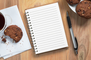 Notebook and coffee with cookies