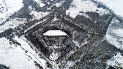 Aerial view of beautiful ancient fortress in forest in winter. Tarakaniv Fort.
