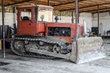 Fototapeta na wymiar Tractor. Agricultural machinery tractor. tractor with pick-up, grader. Parking of tractor agricultural machinery. The picture was taken at a parking lot of tractors in a rural garage on the outskirts