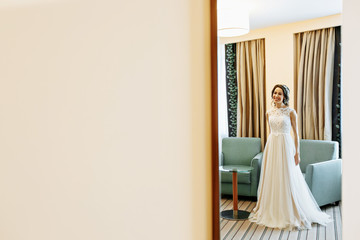 Fototapeta na wymiar Beautiful bride posing in wedding dress in a white photo Studio. Mirror.