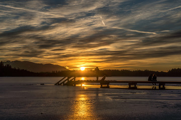 Spaziergänger genießen den Sonnenuntergang am See