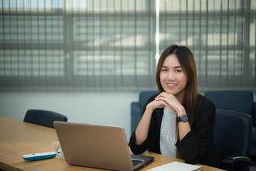 Beautiful asian woman working at the office  in the evening,Thailand worker writing book in the company