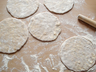 Khachapuri with cheese and cottage cheese. Raw dough on the table. Workpiece for Georgian khachapuri. Cheese cakes.