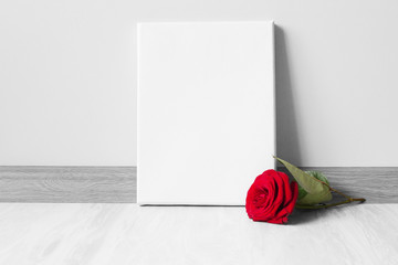 Mockup poster frame and red rose.Neutral gray wall and floor on background.