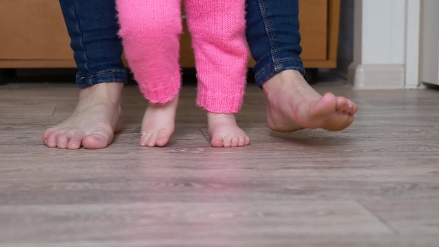 legs of child and mother go barefoot on floor
