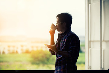 Fototapeta premium woman standing near window drinking coffee.