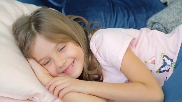 Cute Little girl trying to sleep in her crib and smiling