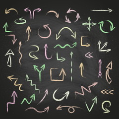 Hand drawn doodle arrows set made of chalk or pastel texture on a blackboard background.
